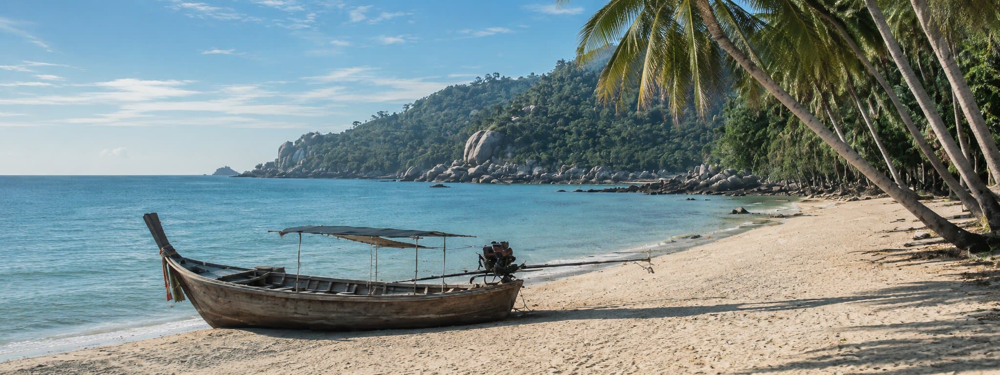 Editorial view of a Koh Samui shoreline with a longtail boat