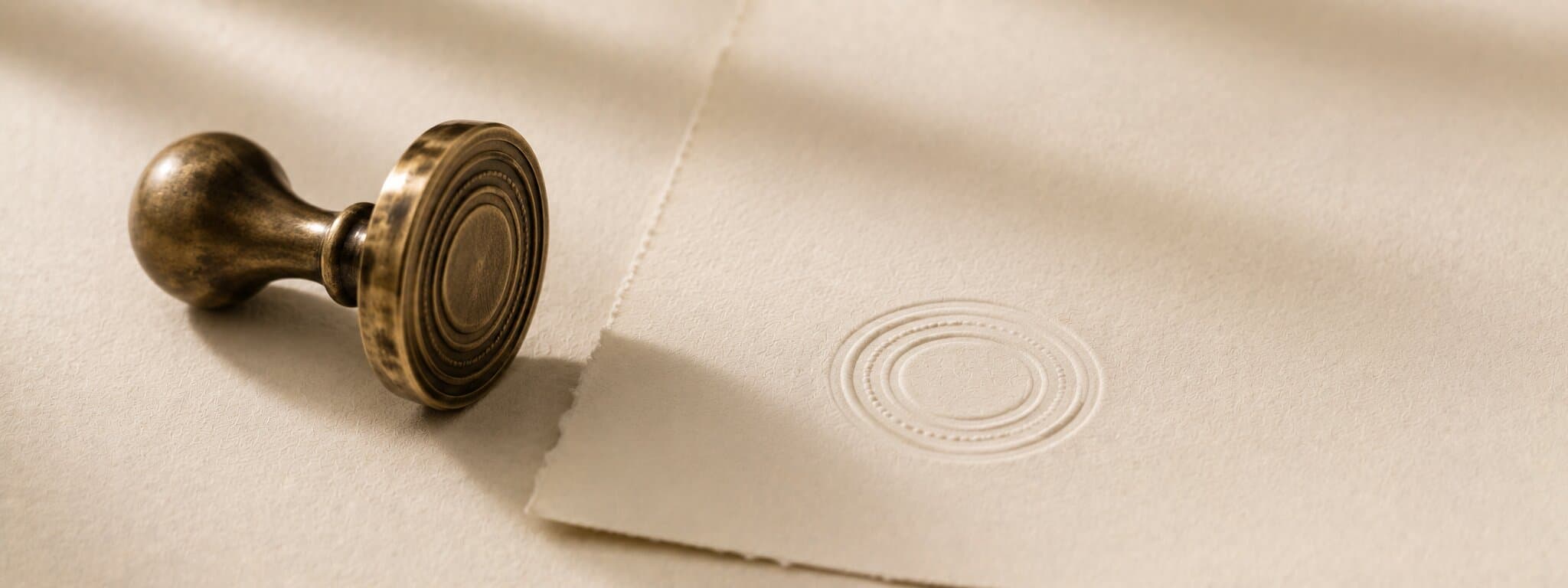 Editorial still life of a brass embossing seal on cotton paper