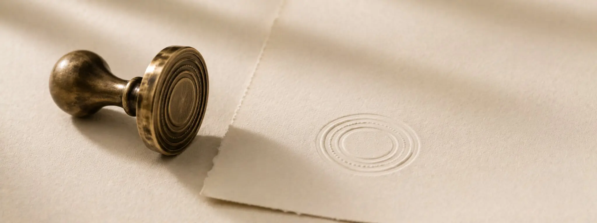 Editorial still life of a brass embossing seal on cotton paper